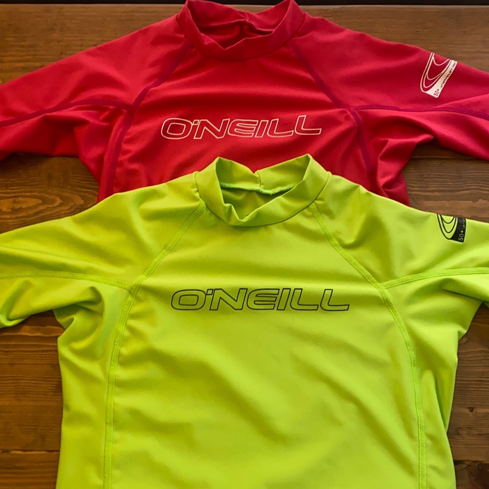 (2) O’Neill surf / beach shirts. One pink, one green.